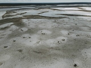 Aerial video of a dry empty field on a sunny day with unique patterns made by nature