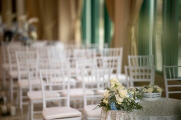 Interior of wedding styling and decor table with flowers, chairs blurred background
