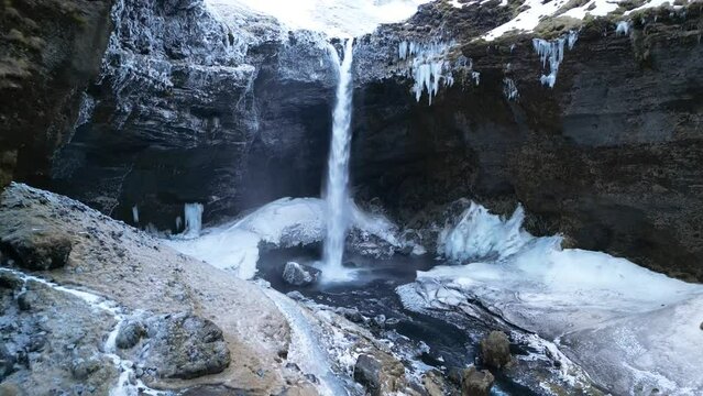 Beautiful view of a wonderful mountain waterfall Kvernufoss in Iceland in winter