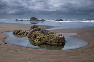 Sand beach with pools of water and rocks. Cannon Beach in Oregon. Portland. USA