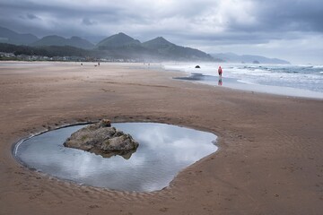 Sand beach with pools of water and rocks. Cannon Beach in Oregon. Portland. USA