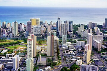 an aerial view of a city with many tall buildings and ocean