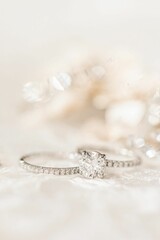 A closeup shot of two diamond wedding rings on a white surface