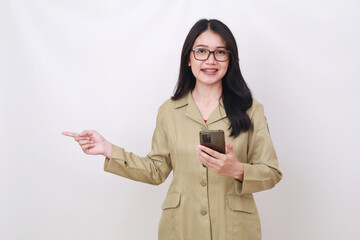 Pretty young Indonesian civil servant worker holding cell phone while pointing beside