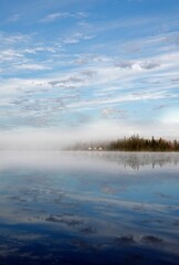 Obraz premium Vertical shot of a serene lake in a remote location, surrounded by nature