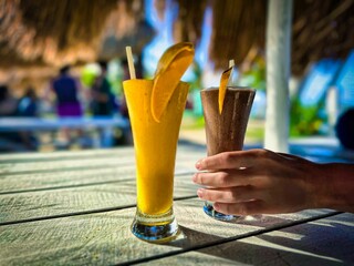Person holding a drink with an orange slice on it.
