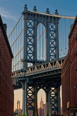 Vertical shot of the Brooklyn bridge seen through buildings in New York, U.S.