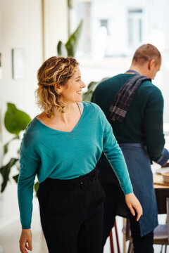 Woman Coming Home From Work While Husband Puts Dinner On The Tabe