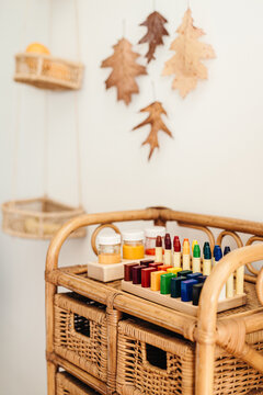 Watercolors, block and stick crayons kept on a vintage rattan rack