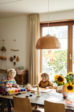 Adorable siblings painting together at homeschooling