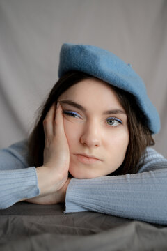 Woman In Blue Leaning On Hand Bored 
