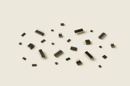 Black micro-controllers scattered on beige background.