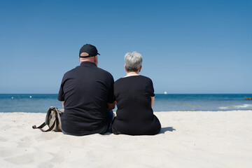 Ehepaar sitzt am Strand der Ostsee bei Kühlungsborn und genießt den Sommertag im Urlaub