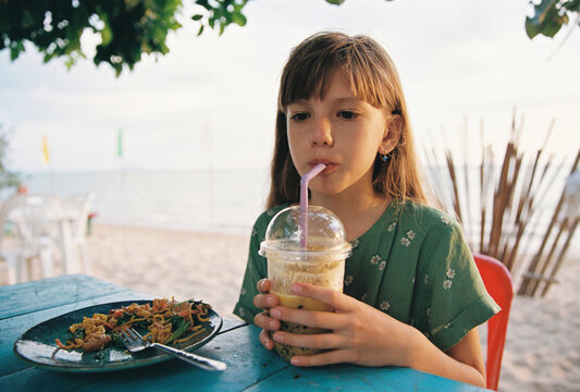 A girl with a smoothie in a beach cafe