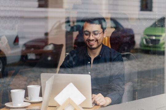 A man smiling and working in an office.