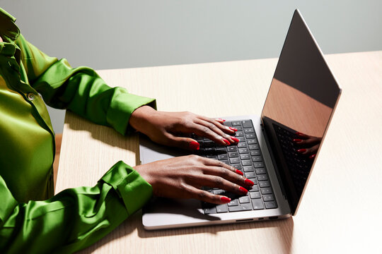 Unrecognizable black woman typing on laptop
