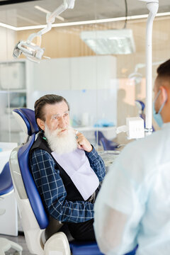Dentist consultation. Pensioner. Protective clothing. Clinic