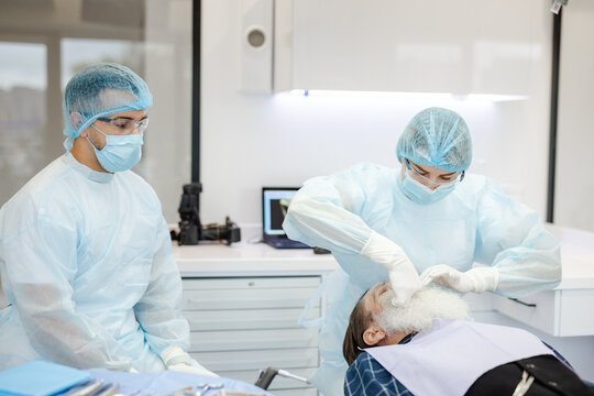 Operating theatre. PPE. Skilled dentist. Teamwork. Mature. Health