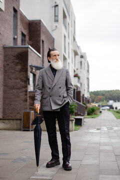 Casual retiree. Suburb. Pavement. Avenue. Parasol. Relaxed