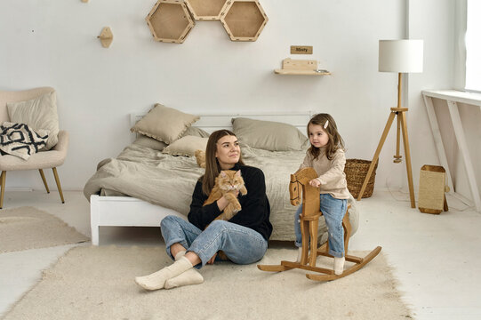 A young mother playing with her child in a bedroom