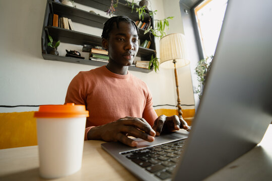 A man uses a laptop indoors