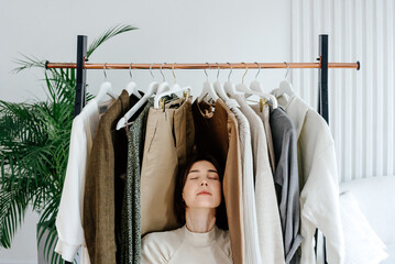 Woman sitting near rack with clothes