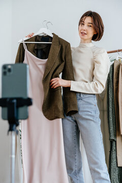 Blogger stylist showing followers trendy look on hangers 