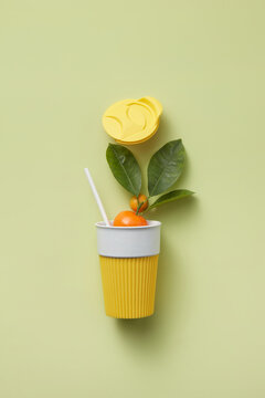 Reusable cup with bamboo straw and tangerine.