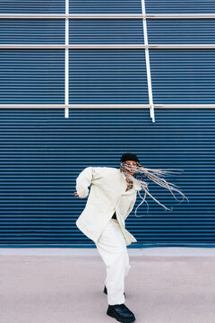 Stylish woman dancing with flying hair on street