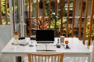 Workplace with laptop and diary during daytime