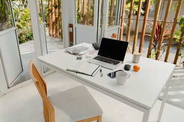 White table with netbook on veranda