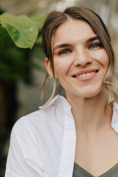 Smiling woman near green plant