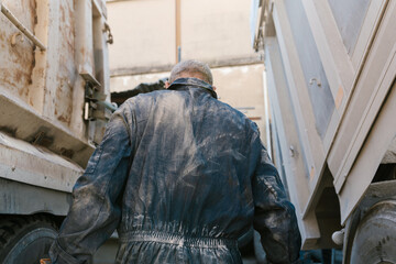 Unrecognizable worker standing between trucks