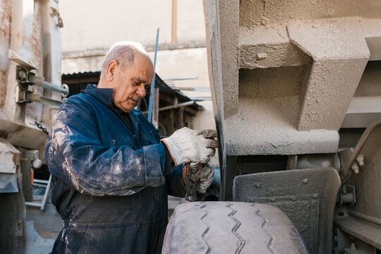 Senior mechanic fixing wheel of truck