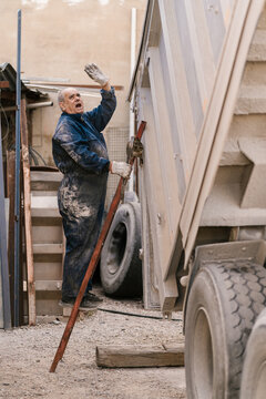 Mechanic standing on truck stairs and screaming