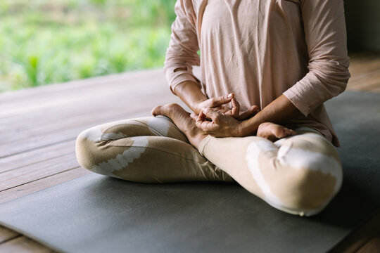 Anonymous woman meditating and holding mantras