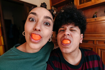 Funny self-portrait of couple eating a clementine