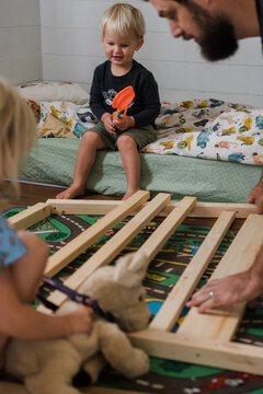 toddler boy watching his first full sized bed be constructed 