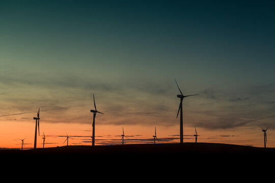 Renewable energy with wind turbines at sunset