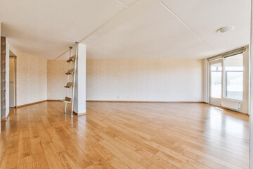an empty living room with wood flooring and white wallpapers on the walls, in a large open space