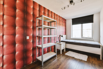 a bedroom with red wallpaper on the walls and bed in the room is made out of metal shelvings
