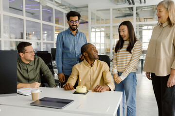 Businesspeople birthday celebration workplace daylight meeting  