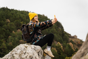 Cheerful Female Taking Selfie Against Mountains
