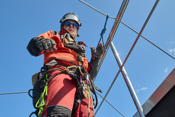 A specialist is repairing the roof. Rope access