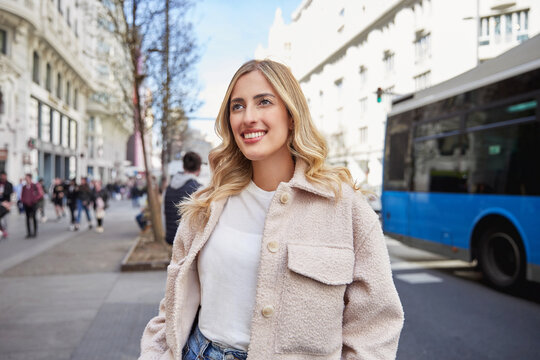 Young Woman Smiling And Walking In City Center