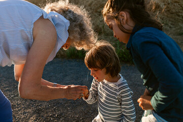 Grandmother taking out a splinter from grandchild 