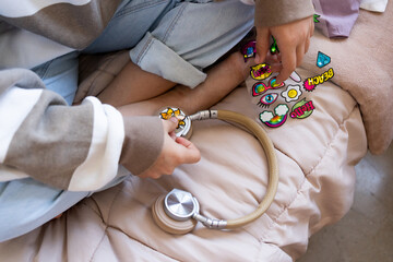 Preteen girl decorating her headphones with stickers 