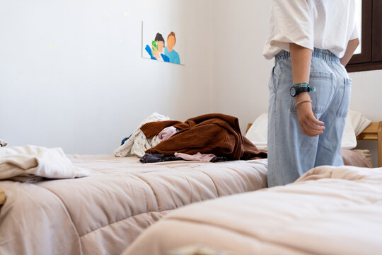 Preteen girl sorting clothes at her bedroom 