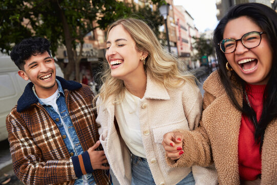 Friends Walking Together In The City Center, Laughing And Smiling.