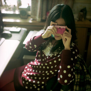 Women take photos with miniature cameras